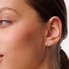 a close up of a person wearing some kind of earring on their left ear