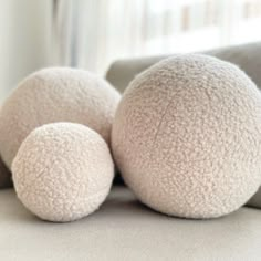 three white balls sitting on top of a couch