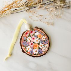 a flower decorated cookie next to some dried flowers