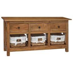 a wooden table with two baskets on top and towels hanging from the drawers in front