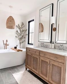 a bathroom with two sinks, mirrors and a bathtub in the middle of it