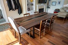 a dining room table with chairs and a fire place in the backround area