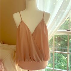 Style Deals - A Beautiful Mauve Polyester Bodysuit Featuring A Surplice Neckline, Open Back, Cami Adjustable Straps, And A Cheeky Bottom With Snap-Button Closures. Elegant One-piece Top For Spring, Chic One-piece Tops For Spring, Pink Bodysuit, Surplice Neckline, Snap Button, Open Back, Adjustable Straps, Womens Tops, Pink