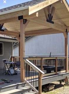 a covered patio with wooden steps and railings