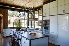 a large kitchen with an island in the middle and lots of windows on both sides