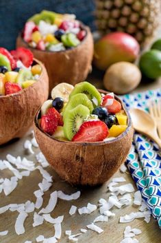 two wooden bowls filled with fruit on top of a table