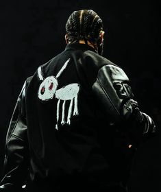 a man with dreadlocks wearing a black jacket and white horse embroidered on it