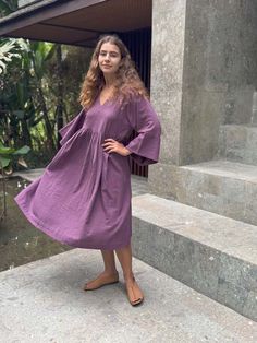 The purple gathered dress created in collaboration with erica kim features a beautiful shade of purple carefully crafted by our artisans to complement all skin tones. its oversized silhouette and roll-up sleeves add a relaxed effortless vibe while the gathered waist and v-neckline introduce a subtle touch of femininity. this versatile piece offers a perfect balance of comfort and style making it a standout addition to your wardrobe.    - purple  - oversize  - roll-up sleeve  - 100 % handwoven organic cotton  - v neck  - roomy side pockets  - gathers  - midi length  - straight hem    size & fit    - falls 45” from  the point of shoulder  - runs larger  -  oversized fit around the body  - midweight non-stretchy fabric  - every style has a different size. please check the size chart before or Erica Kim, Shade Of Purple, Gathered Dress, Roll Up Sleeves, Mid Dresses, Oversized Silhouette, The Purple, Shades Of Purple, Tulle Dress