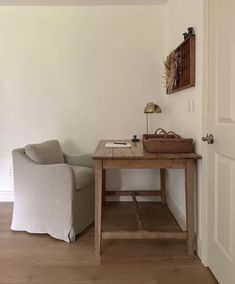 a living room with a couch, table and lamp on it's side wall