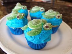 cupcakes decorated with blue frosting and green sea creatures on top of each other