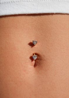 two diamond studs on the belly of a woman's stomach are seen in this image