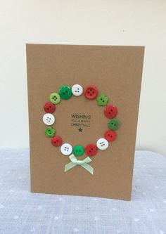 a card with buttons on it sitting on a table next to a white and green ribbon