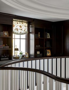 a living room filled with lots of furniture and bookshelves next to a window