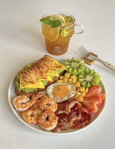 a white plate topped with different types of food next to a cup of tea and fork