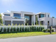 a large white house sitting on top of a lush green field