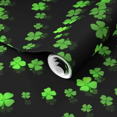 a black background with green shamrocks on it