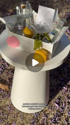 a white hat with lemons and bottles in it sitting on top of the ground