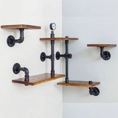 two wooden shelves with metal pipes and brackets on the wall next to eachother