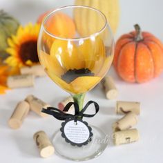 there is a wine glass with sunflowers in it and corks around it