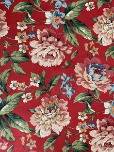 a red floral fabric with blue, pink and green flowers on the bottom half of it