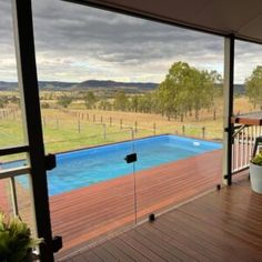 an empty deck with a pool in the middle and grass on the other side as well