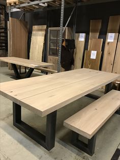 a table and bench in a room with wood flooring on the walls, and several other pieces of furniture behind it