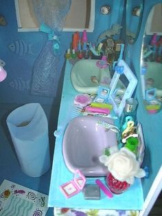 there is a sink and mirror in this dollhouse bathroom with toys on the counter