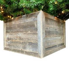 a wooden box with christmas lights in it on top of a white background that looks like an evergreen tree