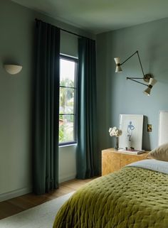 a bedroom with green bedding and curtains