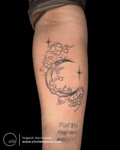 a man's arm with a tattoo on it that has a crescent moon and stars