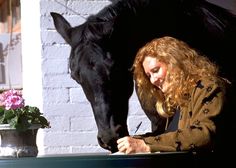 a woman writing in front of a black horse