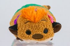 a small stuffed animal with orange hair on it's head