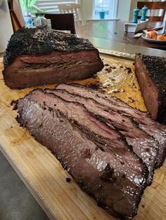 two large pieces of meat sitting on top of a cutting board next to each other