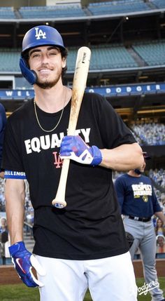 a man holding a baseball bat in front of a stadium filled with people and fans