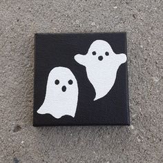 two ghost faces painted on black and white canvases