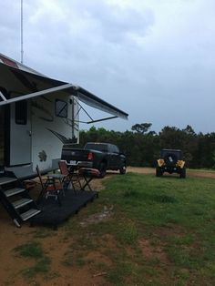 a truck parked in front of a camper with stairs leading up to the roof