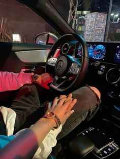 a person sitting in the driver's seat of a car with their hands on the steering wheel