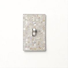 a mother of pearl light switch cover on a white wall