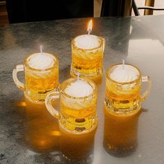 three mugs with candles sitting on a table