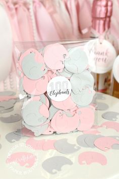 pink and gray elephant baby shower decorations on a table with thank you tags in the center