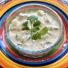 a bowl filled with soup and garnished with cilantro on a colorful plate