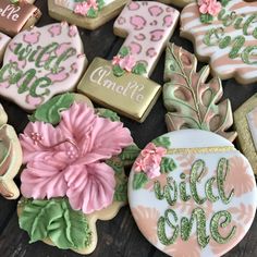 decorated cookies with the words will one be spelled on them and pink flowers in front