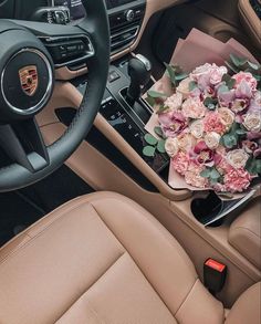 a bouquet of flowers is sitting in the center console of a car, next to a steering wheel