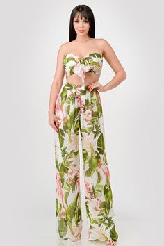 Effortlessly chic and versatile, the Olive Pink set features a tropical floral print in lightweight crepe chiffon. The smocked back and knot front tie provide a flattering fit, while the tube cropped top and wide leg palazzo pants offer comfort and style. Perfect for any occasion, this set is a must-have for your wardrobe. Fabric & fit: 100% polyester Model is wearing size small. Chic Floral Print Beach Pants, Chic Beach Pants With Floral Print, Tropical Style Floral Print Beach Pants, Green Tropical Print Pants For Vacation, Cropped Summer Bottoms For Vacation, Summer Cropped Bottoms For Vacation, Summer Vacation Cropped Pants, Cropped Pants For Summer Vacation, Strapless Summer Bottoms For Vacation