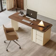 an office desk with a laptop on it and a chair in front of the desk