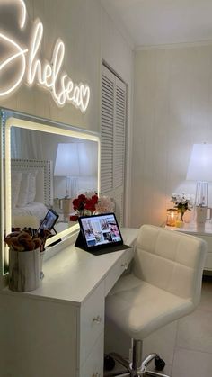 a laptop computer sitting on top of a desk in front of a lighted sign that says sheleen