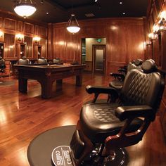 a large room with wooden floors and lots of chairs on the floor in front of a pool table