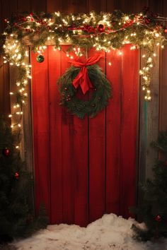 a red door decorated with christmas wreaths and lights