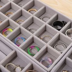 an assortment of rings and bracelets sitting in a box on top of a table