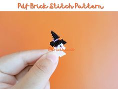 a hand holding a small piece of beaded crafting on an orange background with the words puff brick stitch pattern